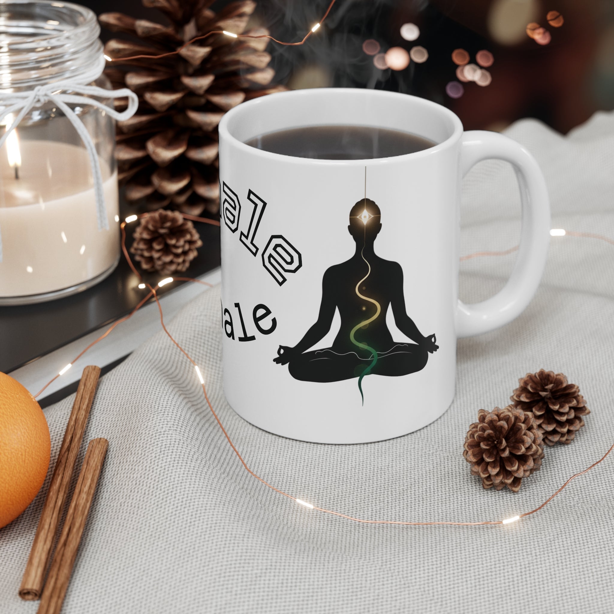 Meditation yoga coffee mug with a serene silhouette, chakra line, and 'Inhale Exhale' text, resting on a cozy table.